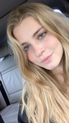 Blonde woman with blue eyes in a car interior
