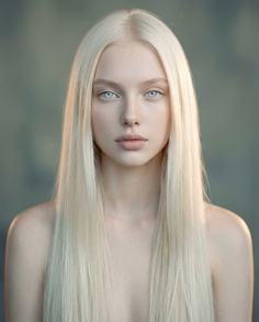 Woman with long blonde hair and blue eyes, looking directly at the viewer