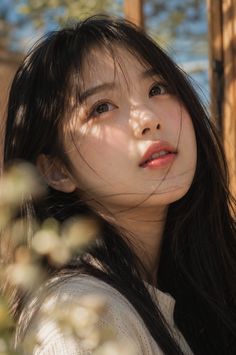 Woman with long black hair looking up with soft lighting on her face
