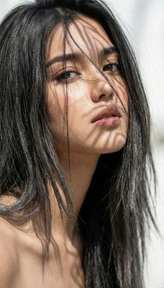 Woman with long black hair and shadows on her face