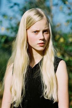 Young woman with long blonde hair wearing a black top outdoors