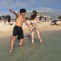 Couple standing in shallow water at a beach on a sunny day