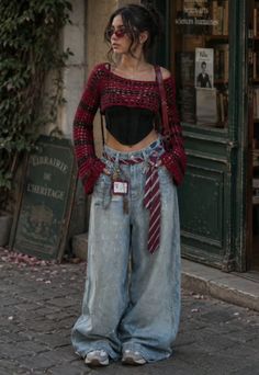 Woman in a cropped sweater, corset top, and wide leg jeans on a street