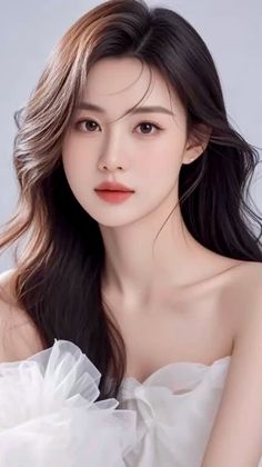 Woman with long wavy hair wearing a white strapless dress