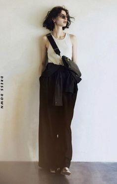 Woman with short hair and sunglasses wearing a tank top and wide leg pants