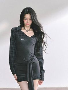 Woman with long black hair wearing a mini dress and plaid shirt