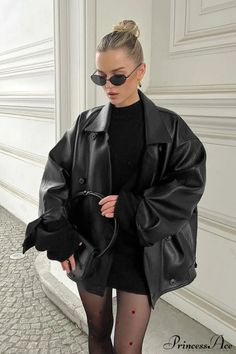 Woman in a black leather jacket, sunglasses, and heart-patterned tights outdoors
