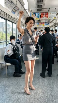Woman in a gray sleeveless shirt and mini skirt standing in a train