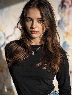 Woman with long brown hair wearing a black shirt and a gold necklace