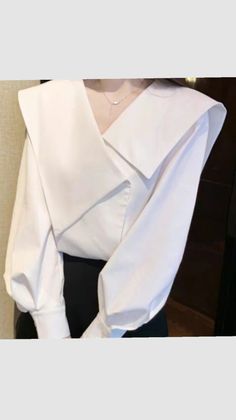 Woman wearing a white blouse with a wide collar and a black skirt