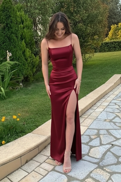 Woman in a red dress with a high slit standing outdoors