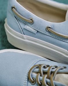 Close up of light blue canvas boat shoes with white soles and brown laces