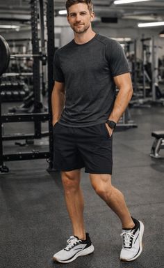 Man in athletic wear standing in a gym with hands in pockets
