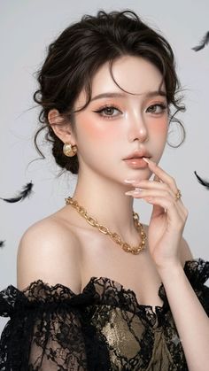 Woman with an updo hairstyle wearing gold jewelry and a black lace top