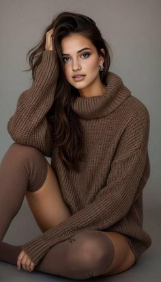 Woman in a brown turtleneck sweater and thigh-high socks posing indoors