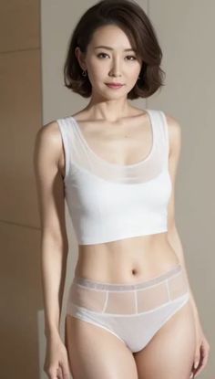 Woman with short hair wearing a white top and underwear indoors