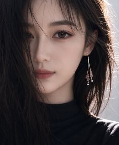 Woman with long black hair and earrings in a close-up portrait