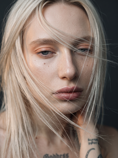 Close up portrait of a woman with blonde hair covering her face