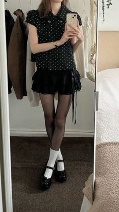Person in a polka dot top and mini skirt taking a mirror selfie
