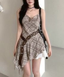 Woman in a plaid dress with a belt and choker standing indoors
