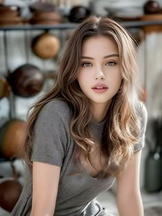 Woman with long brown hair and light eyes wearing a gray t-shirt indoors