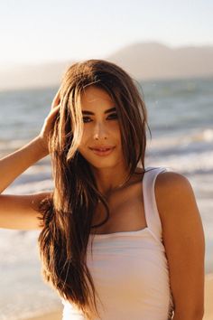 Woman with long brown hair on a beach at golden hour