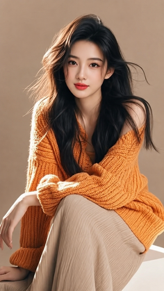 Woman with long dark hair wearing an orange off-shoulder sweater