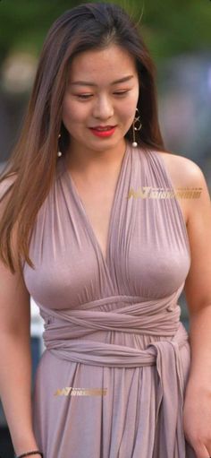 Woman with long hair and red lipstick wearing a light purple v-neck dress