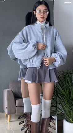 Woman in an oversized jacket and pleated skirt with a mirror reflection