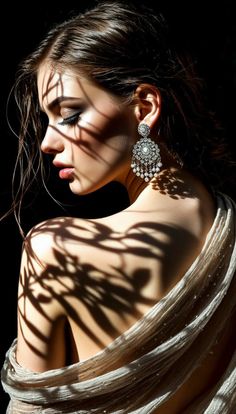 Woman with wet hair and large earrings, with leaf shadows on her skin