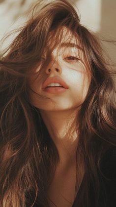 Close up of a woman with long brown hair in soft golden hour lighting