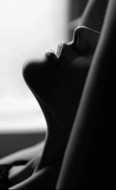 Close up black and white photograph of a person's face in profile with dramatic lighting