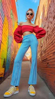 Woman in a red crop top and striped pants in a colorful alleyway