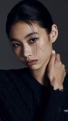 Woman with wet black hair and a black sweater in a studio shot