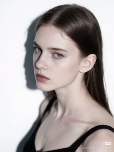 Woman with long hair in a black top with dramatic lighting and shadow