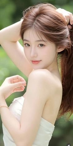 Woman with long brown hair wearing a strapless top outdoors