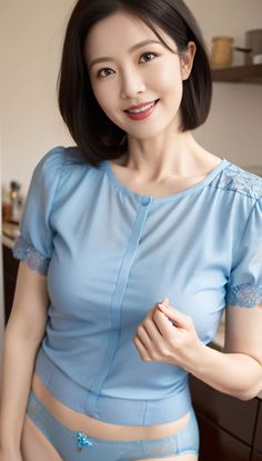 Woman with short hair wearing a blue top and blue underwear, smiling at the camera