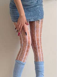 Person wearing a blue mini skirt, fishnet stockings, and leg warmers