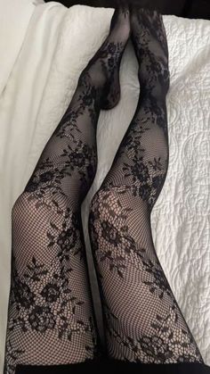 Legs in black lace fishnet stockings on a white bed