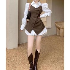 Person in a white shirt and brown vest with long boots and a shoulder bag