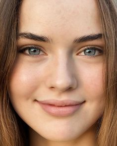 Close up portrait of a young woman with blue eyes and long brown hair