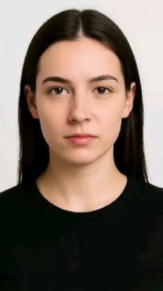 Woman with long black hair wearing a black shirt against a white background