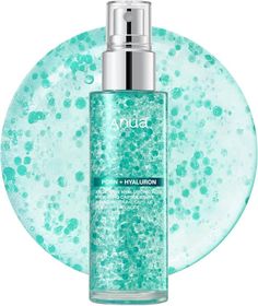 A clear spray bottle with turquoise liquid and silver cap on a white background