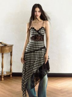 Woman with long dark hair wearing a plaid dress with lace trim indoors