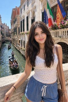 Woman with long dark hair smiling on a bridge over a Venice canal