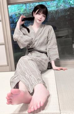 Woman in a yukata sitting on a tatami mat with exposed feet