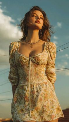 Woman in a floral dress with cleavage, looking up at golden hour