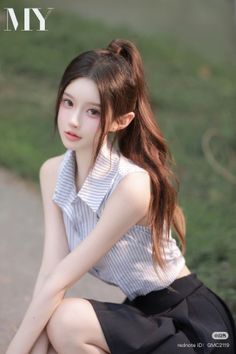 Woman with a ponytail wearing a striped shirt and black skirt outdoors