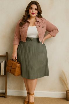 Woman with long hair wearing a pink jacket and pleated skirt, holding a brown handbag