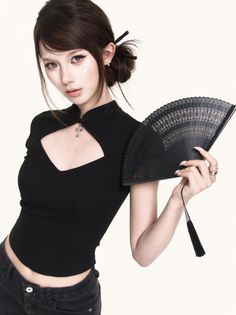 Woman in a black cutout top holding a black fan with an updo hairstyle